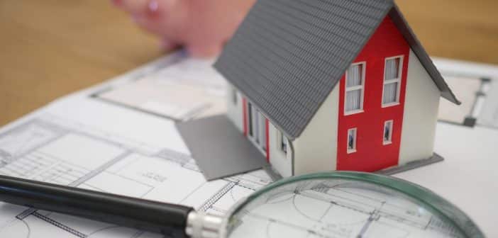 white and red wooden house beside grey framed magnifying glass