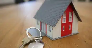 white and red wooden house miniature on brown table