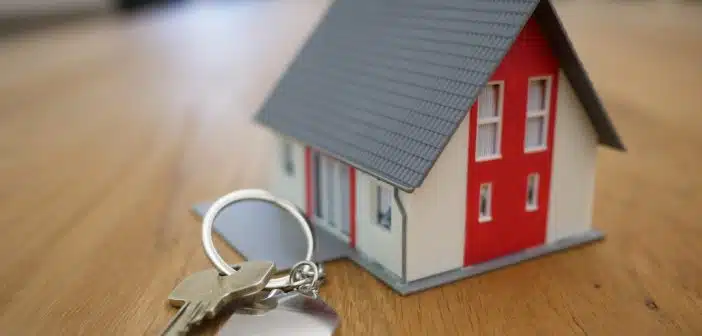 white and red wooden house miniature on brown table